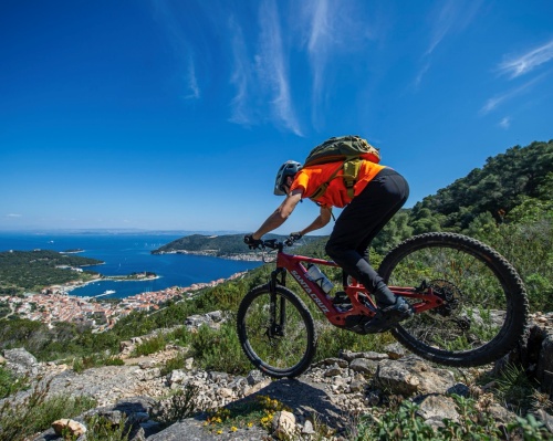 Mountain biker riding a rocky coastal trail overlooking the sea in Croatia
